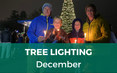 Tree Lighting - December - image of family holding candles in front of the lit christmas tree